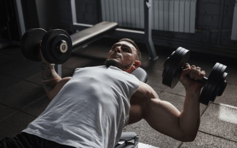 Image of a bodybuilder doing a dumbbell chest press