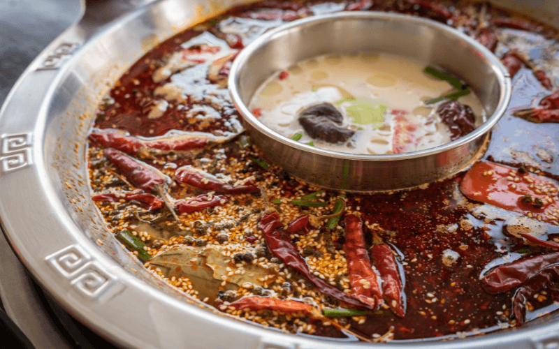 Image of a huge bowl of Ma La Hotpot with chopsticks