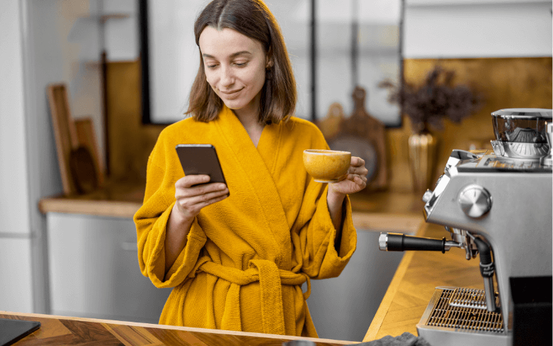 Image of a person having a fresh cup of coffee in the morning, with a smart coffee maker in full view