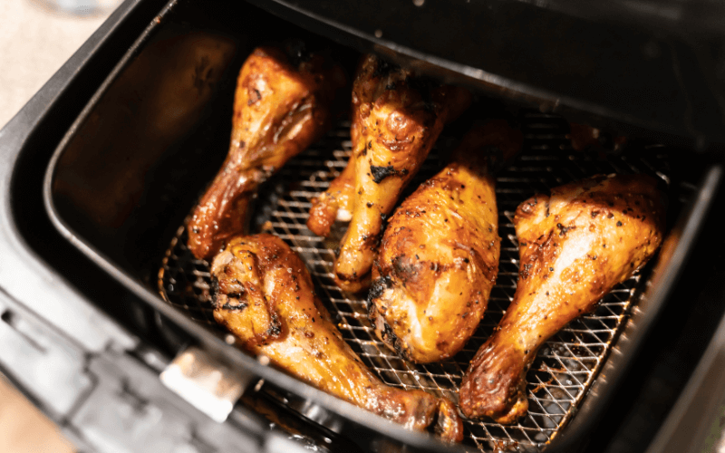 Image of an air fryer being used to fry chicken or fries