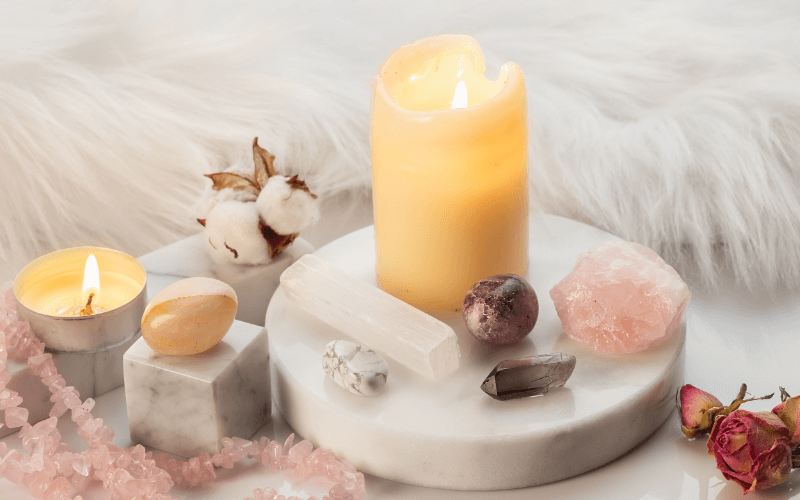 6 Innovative New Age Health Trends To Explore An image of a setting with candles, crystals, and soft lighting