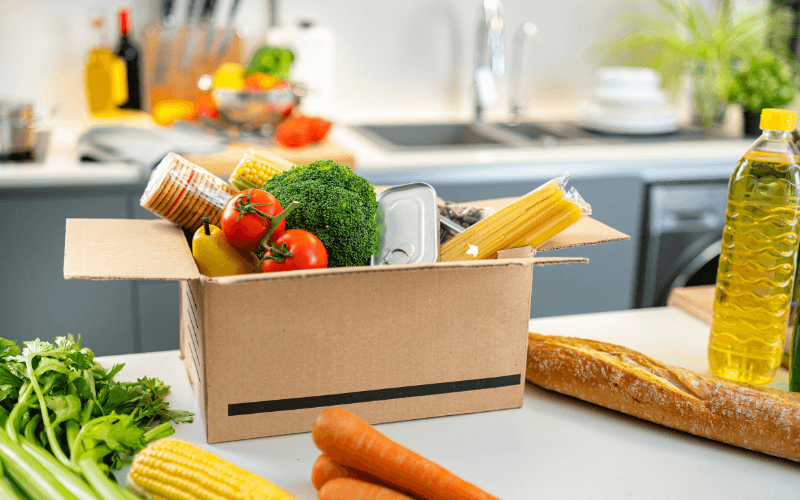 Image of a box of groceries on a kitchen counter.
