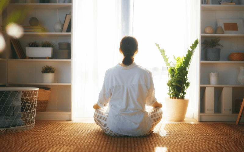 The Busy Person’s Guide To Meditation In Singapore Image of a person meditating at home.