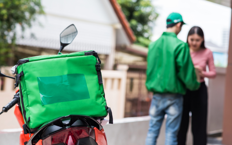 Image of a food delivery service giving their delivery to a customer