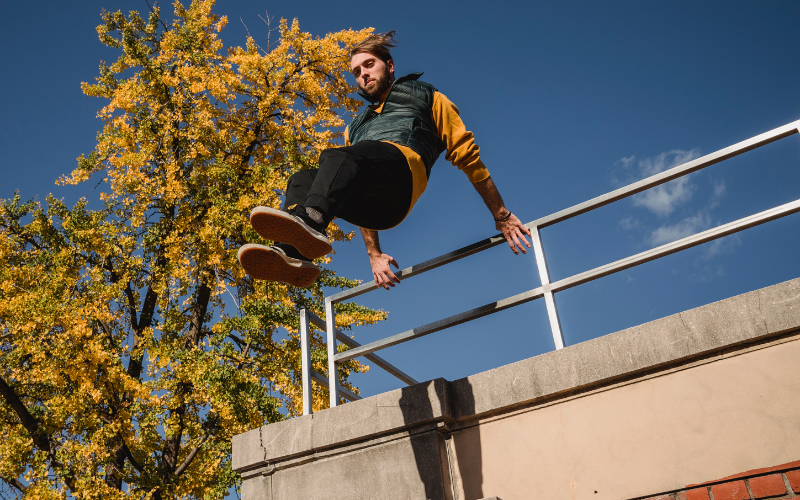 Image of a person jumping over a railing in a parkour pose