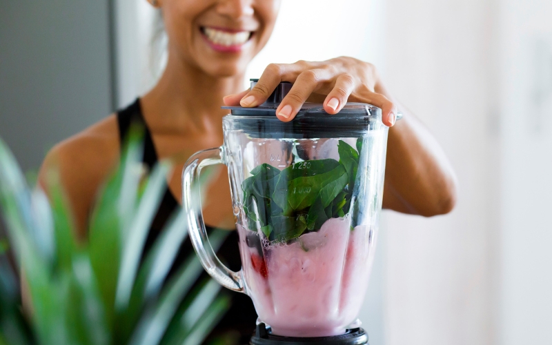 How To Create A Detox Plan With The Right Foods And Juices For Wellness Image of a person using a blender to make a detox smoothie