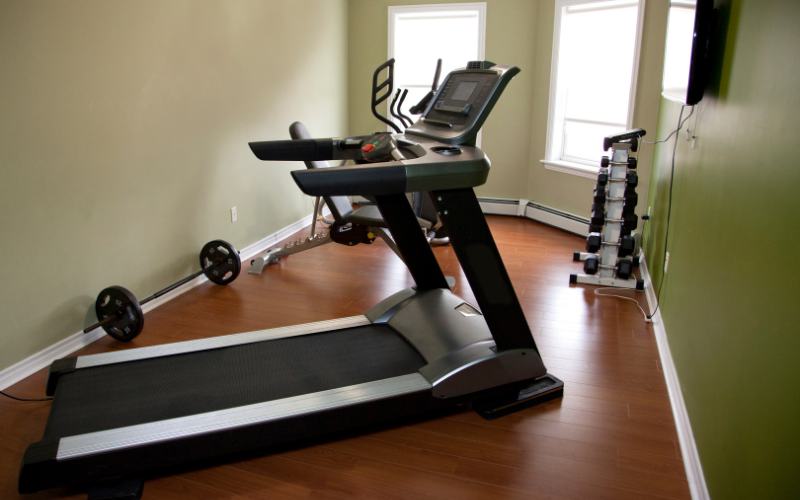 Image of home gym with a treadmill and a cable machine