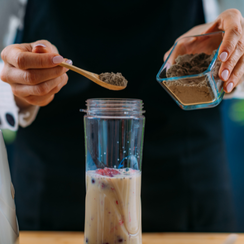 Small image of a person making a smoothie with protein powder and fruits