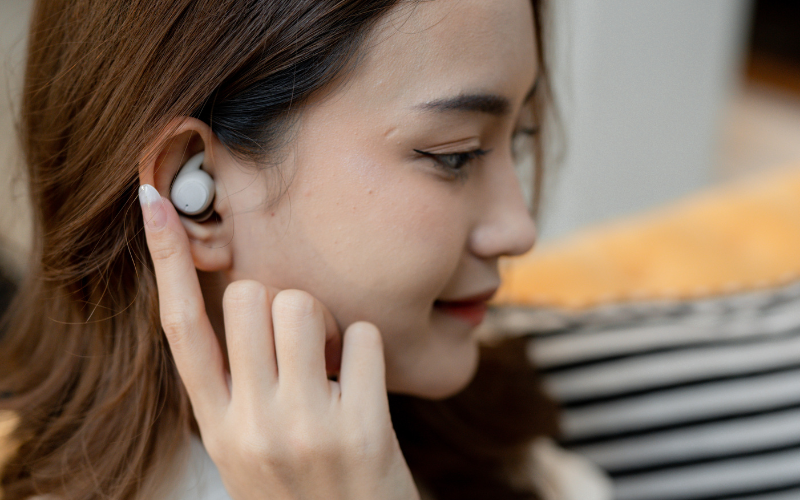 Image of a close-up shot of a person’s head wearing earbuds