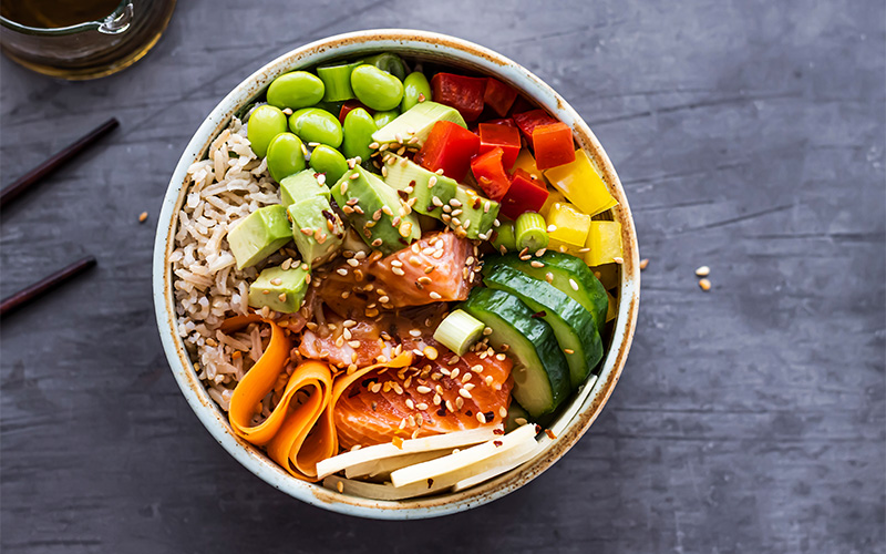 A stock photo of a poke bowl with calorie and protein macros.