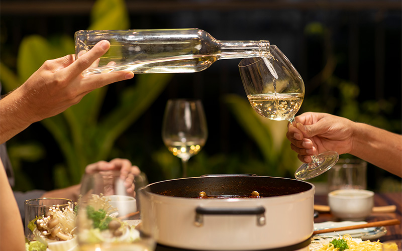 Sommelier pouring wine in a formal restaurant setting.