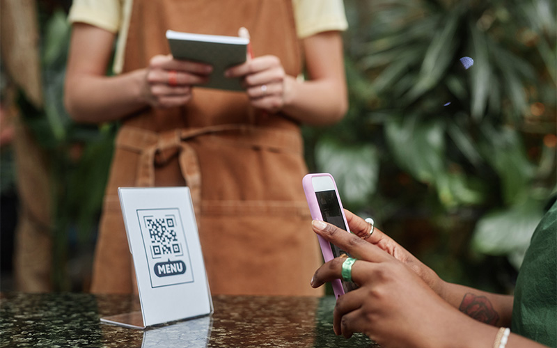 A person scanning a QR code at a buffet restaurant.