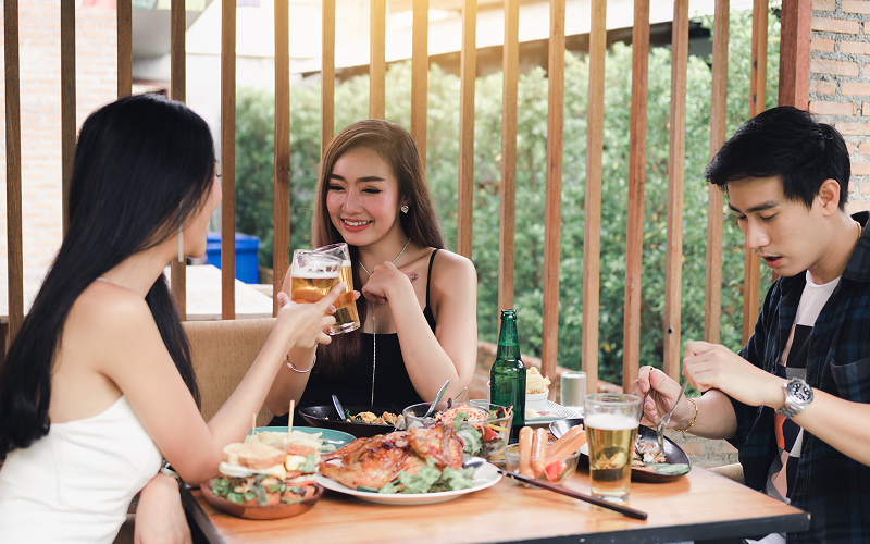 An image of a group of people enjoying some meals and drinks