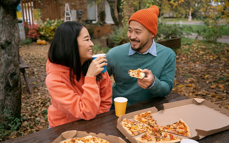 Image of a customer eating pizza happily