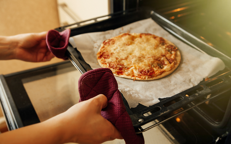 Tech Upgrades Making Pizza Places Faster and Fresher Image of a person baking a pizza