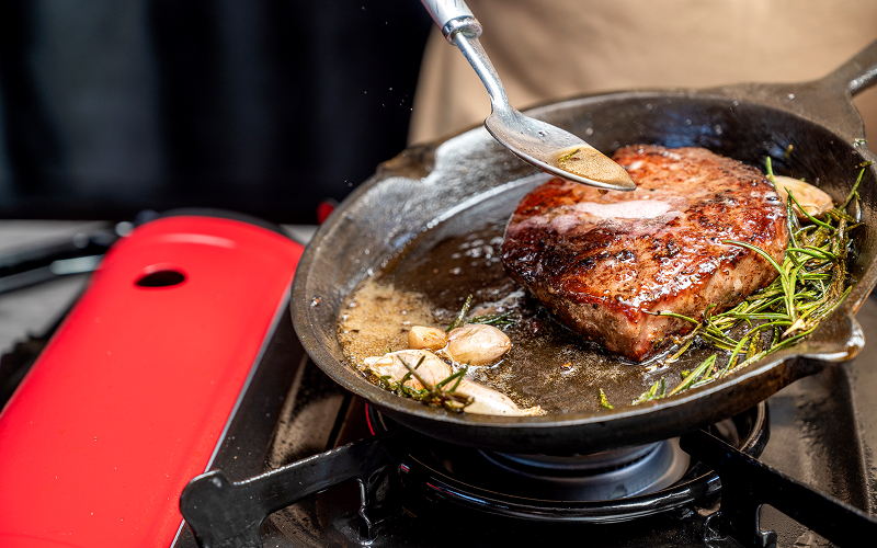 Image of a person cooking a steak