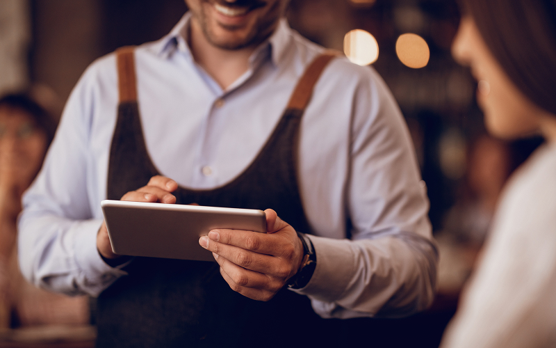 A stock photo of a person using a smartphonewaiter using a tablet