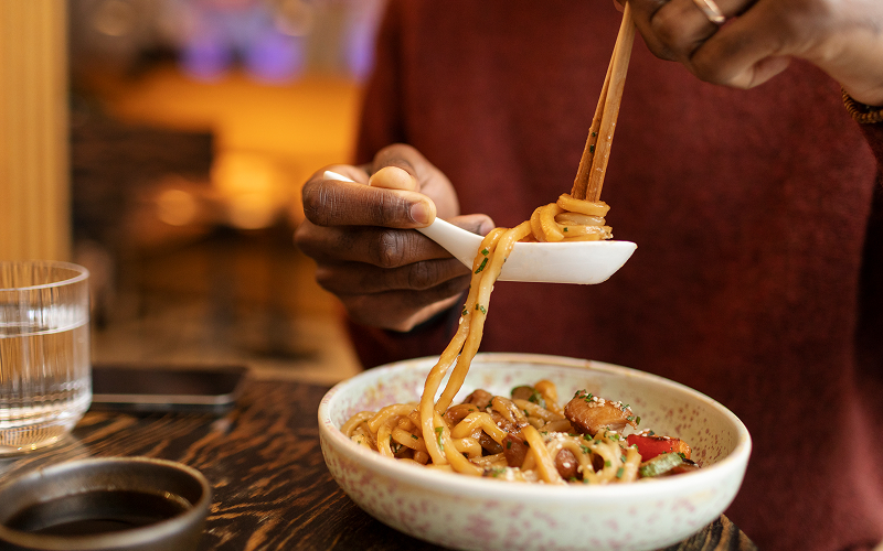 Image of a person at a noodle bar.