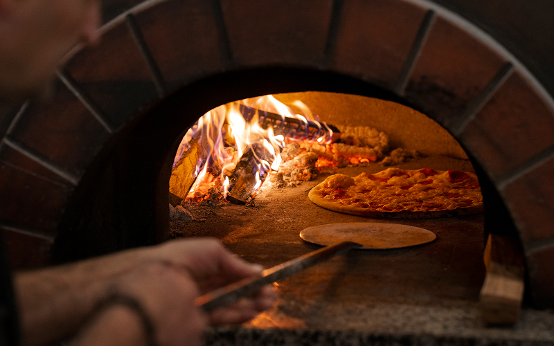 Image of a person using a pizza stone oven.