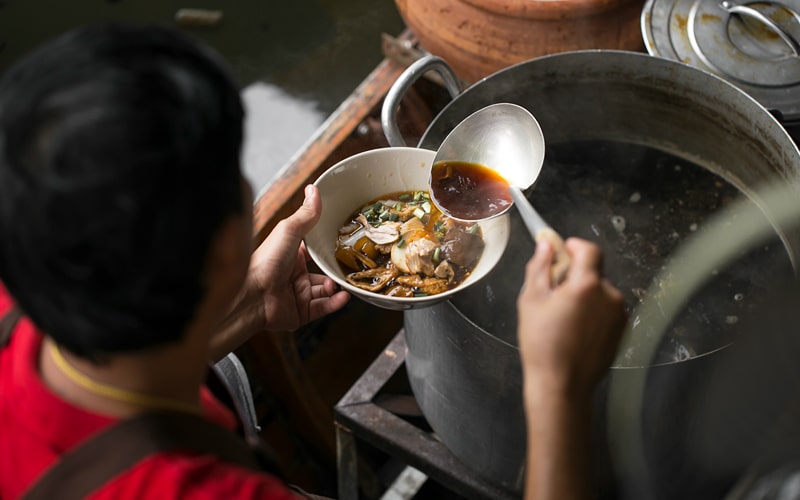a person serving Malaysian food