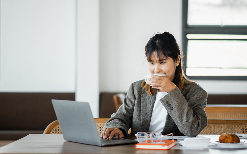 a person drinking coffee at workplace while working