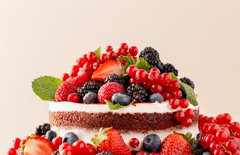 a slice of beautifully decorated fruit-based cake with fruits on top of it