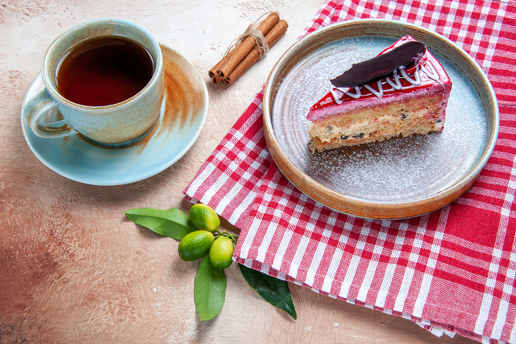 a slice of cake with a cup of tea on a table
