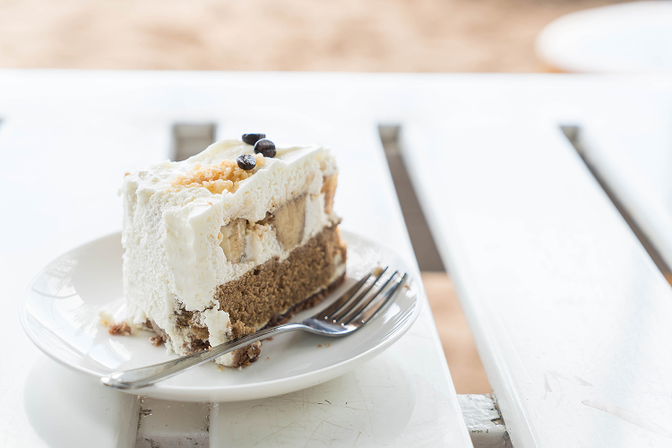 a sliced yogurt cake with simple cream on top of it