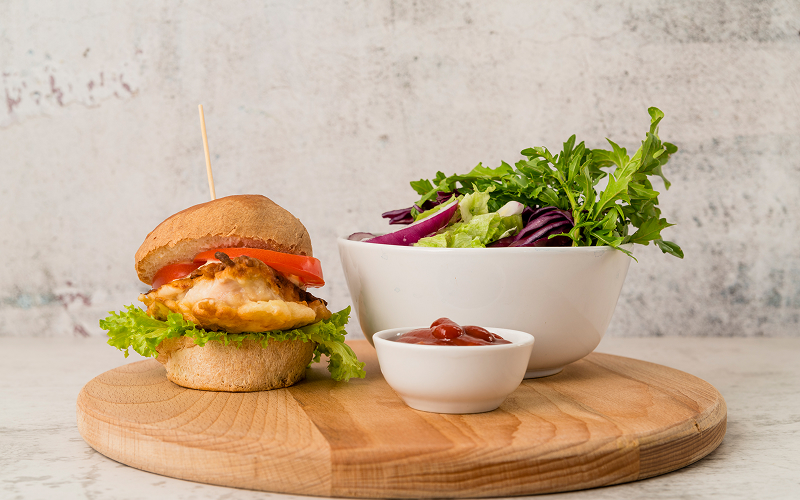 Image of a chicken sandwich and a salad bowl